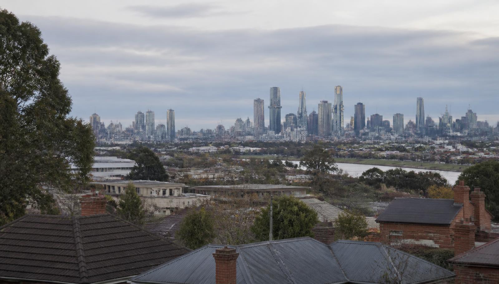 Melbourne city skyline seen across inner-suburban rooftops